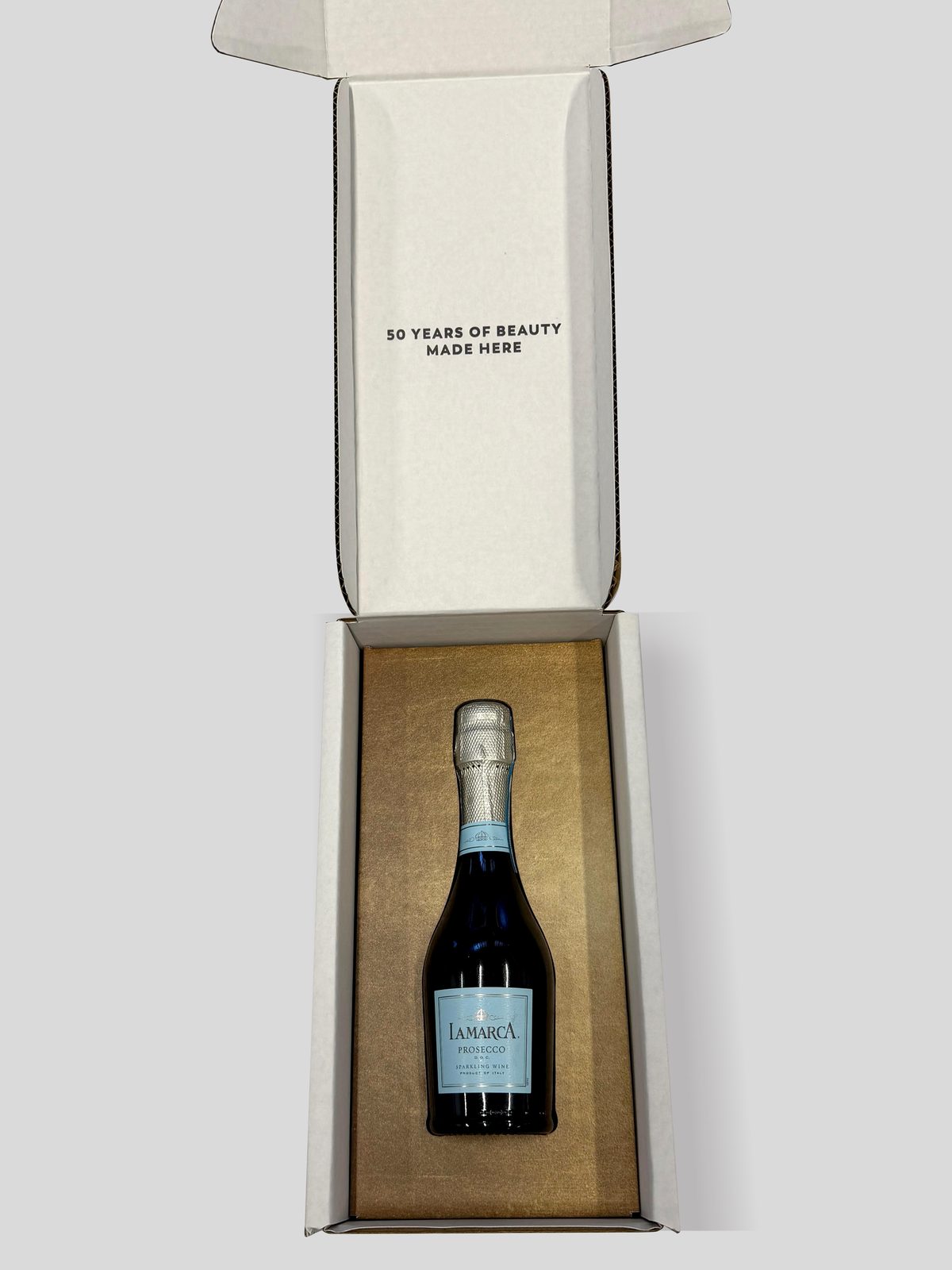 L'Oréal 50th-anniversary white shipping box, open with printed interior and fitted bottle insert