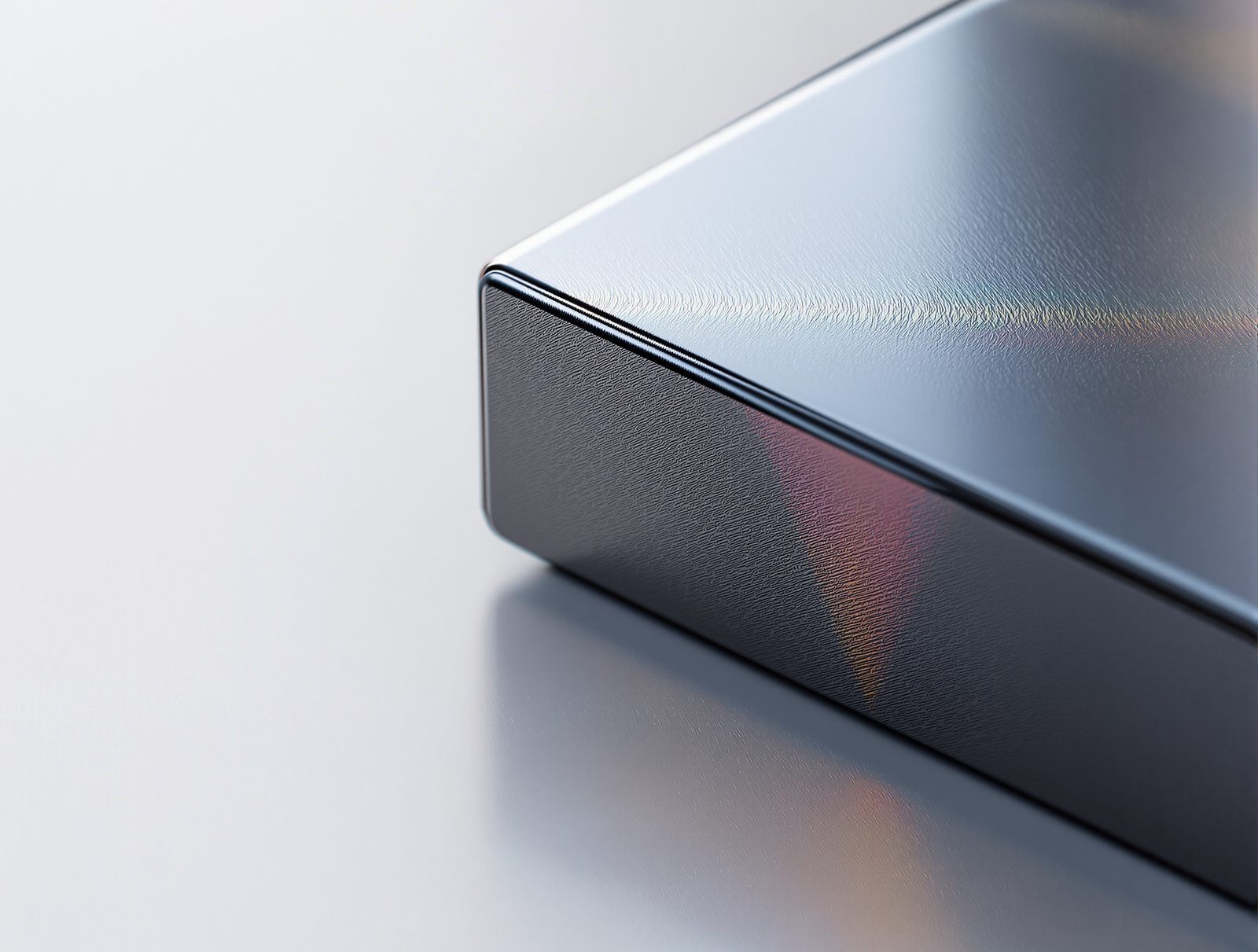 Close-up of a computer screen corner showing a glossy 3D-rendered box with soft studio reflections — studio image
