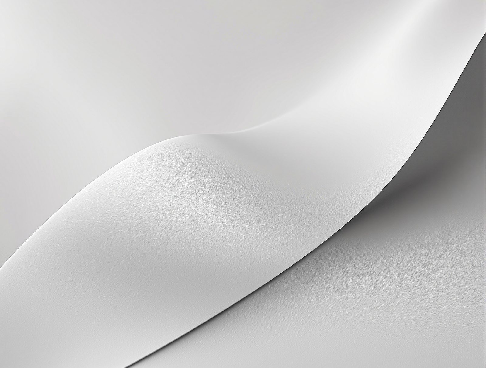 Silk-satin laminated paperboard curling gently, subtle luster along the curve — studio image