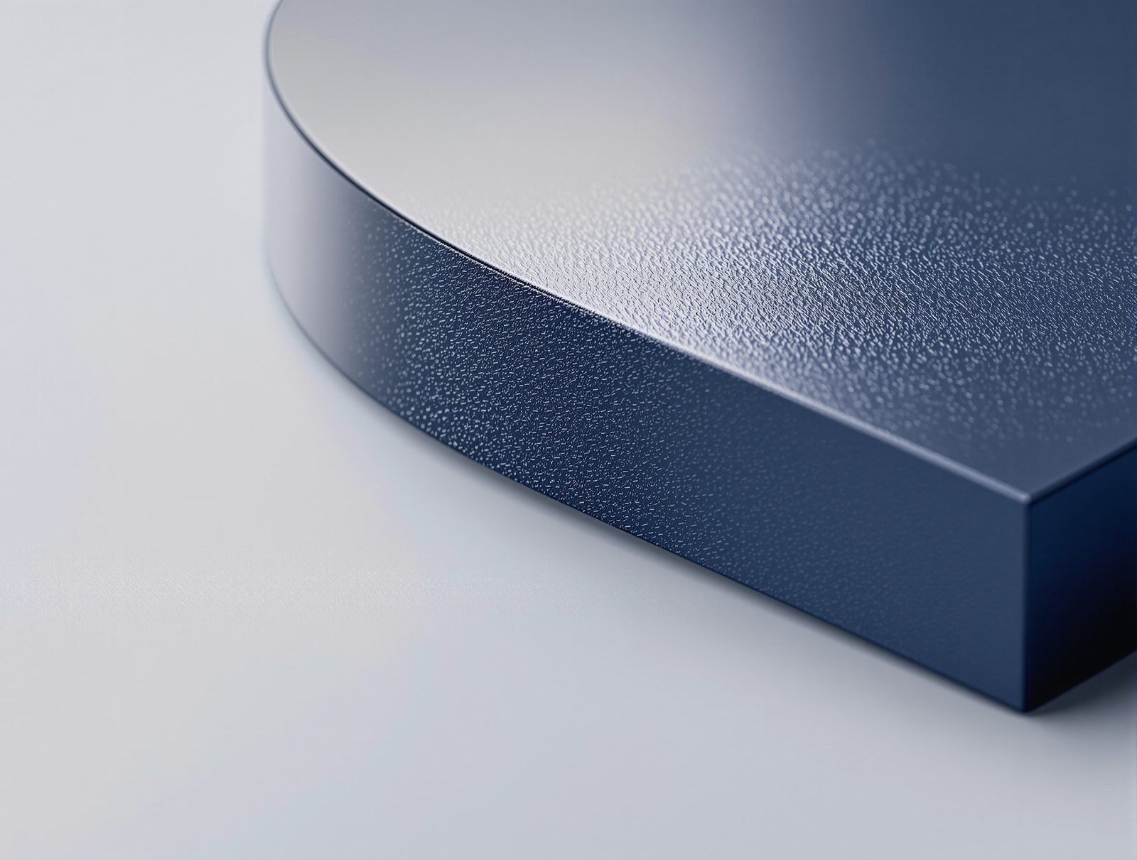 A matte navy surface with mirror-gloss UV coated geometric band reflecting a softbox — studio image