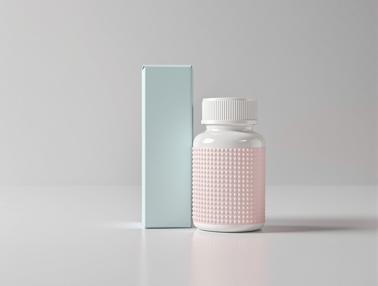 White pill bottle beside a pastel folding carton with braille-style embossed dots — studio image